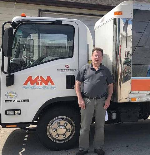 Dennis Abbott, owner of M-M Cleaning Service Bloomington IL, with truck-mounted steam cleaning system